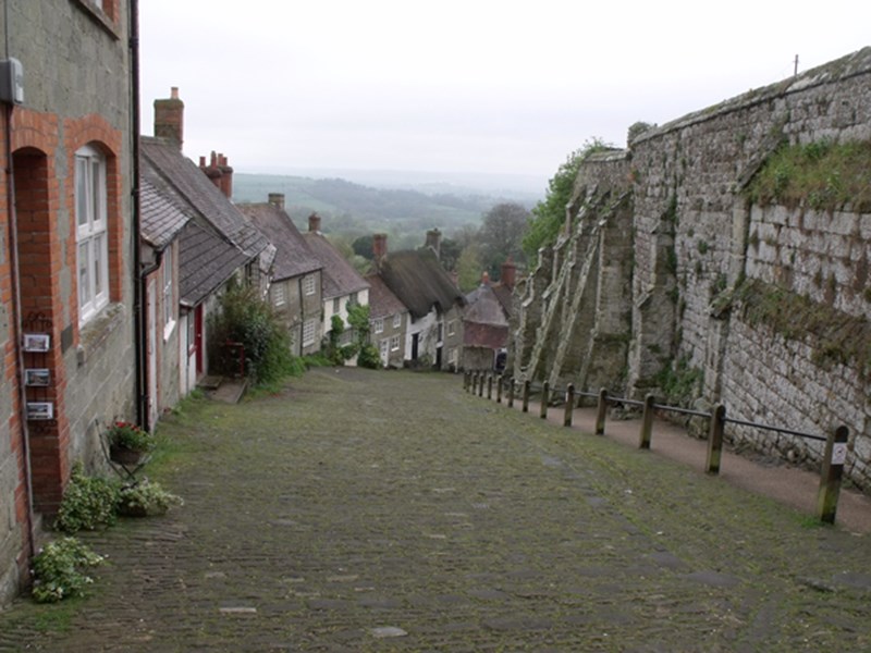 Gold Hill in Shaftesbury, Dorset showing the remains of Shaftesbury Abbey precinct wall on the right.